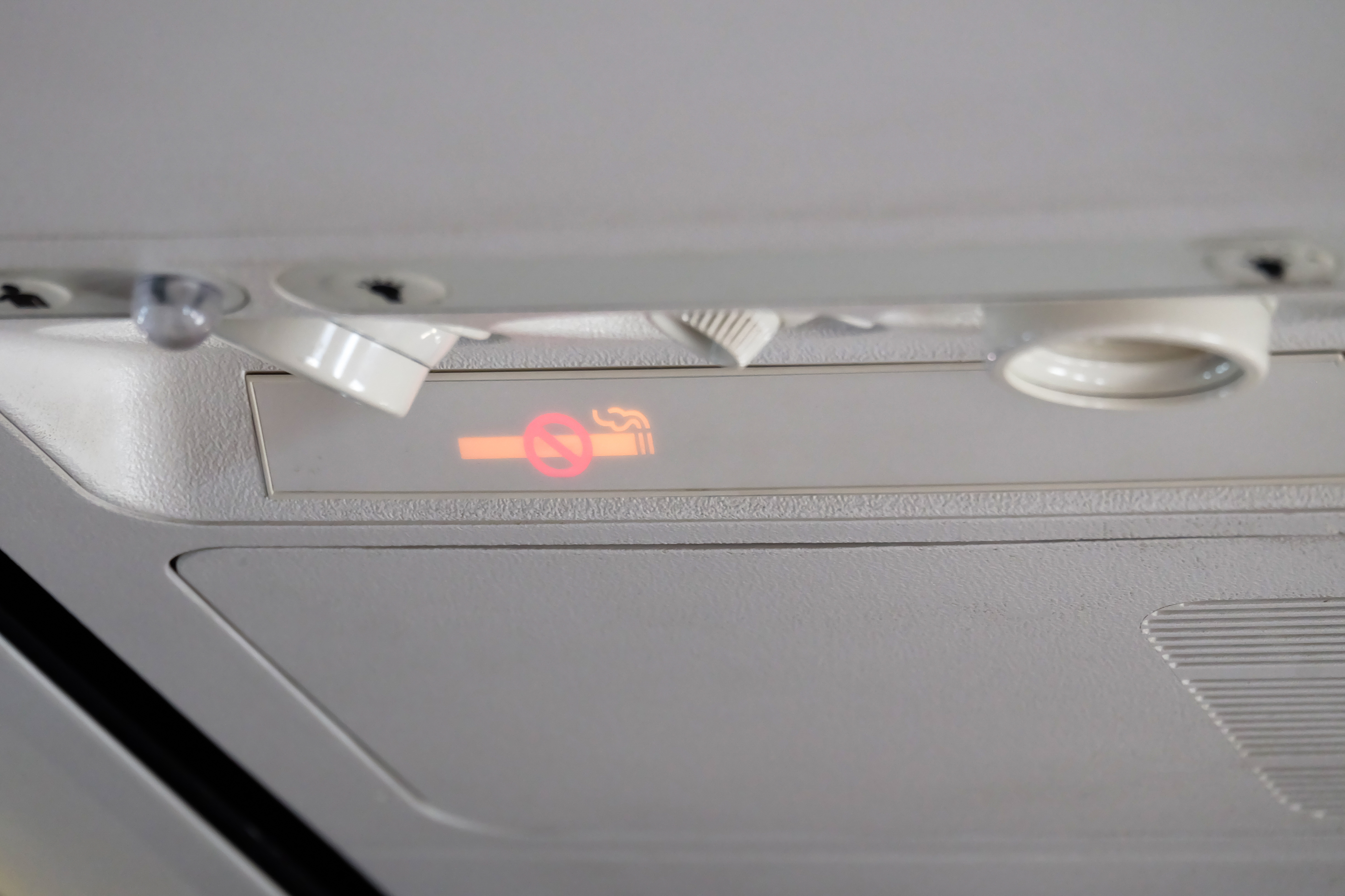 No smoking sign Mounted above the head in the aircraft cabin.