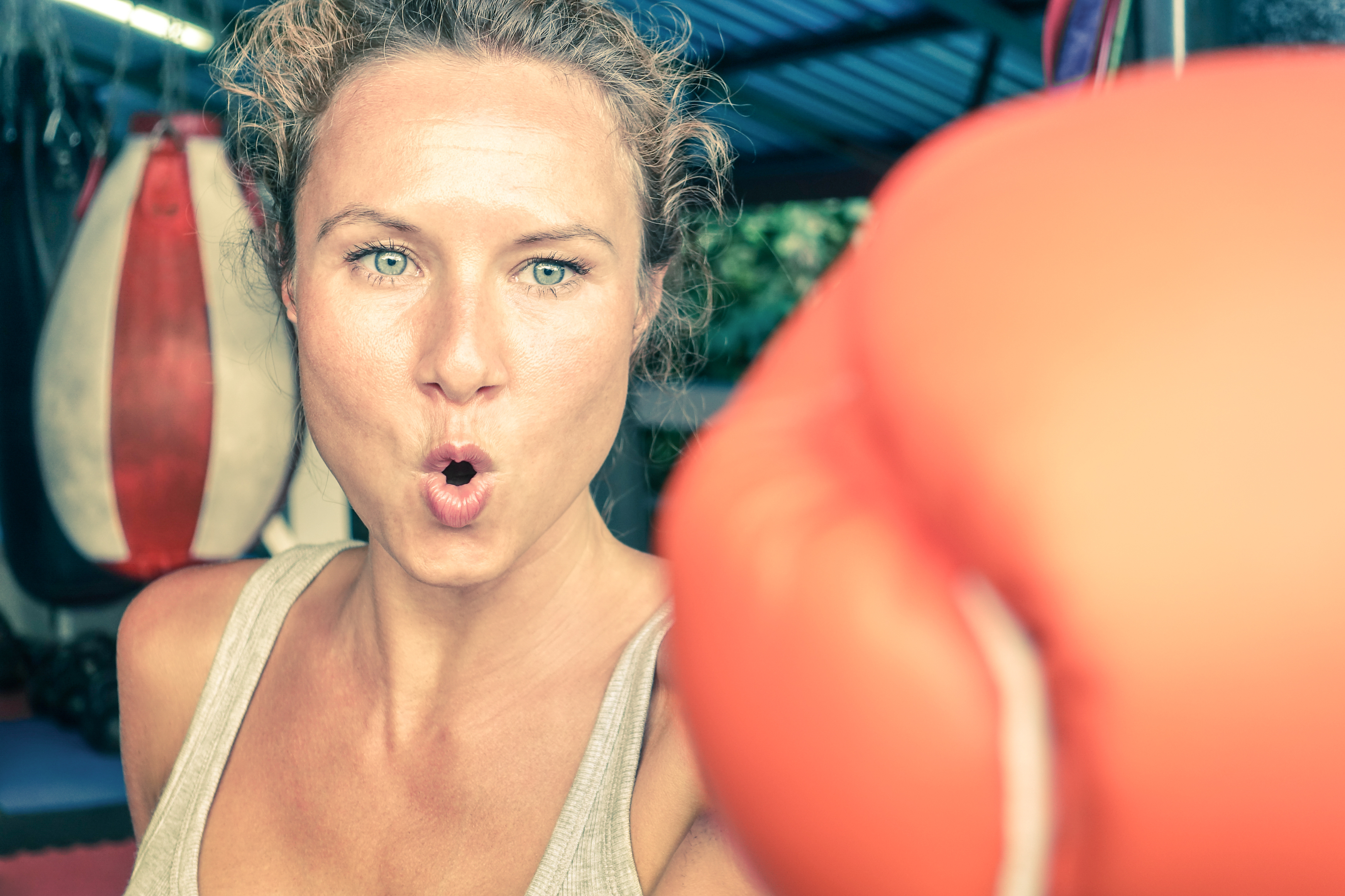 Woman hitting with punch on gritty determination at fitness boxing