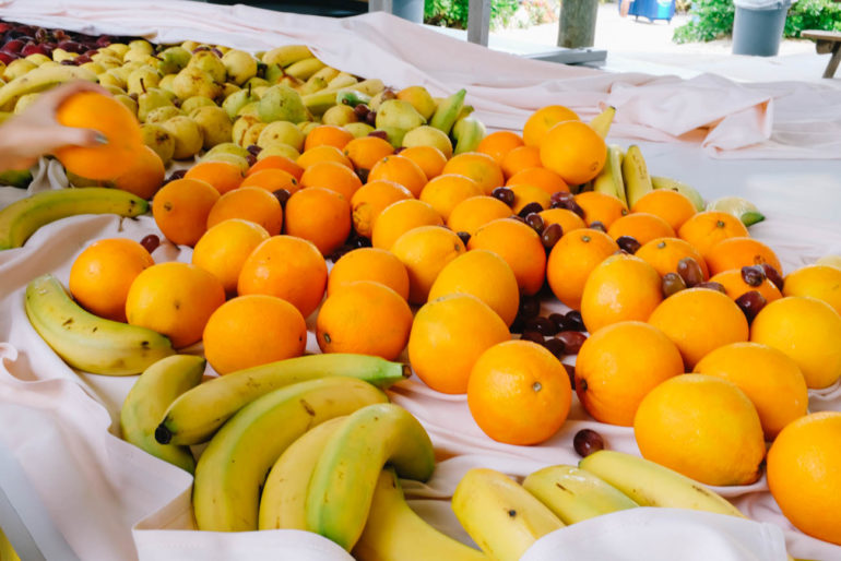 pile of oranges, bananas, and grapes