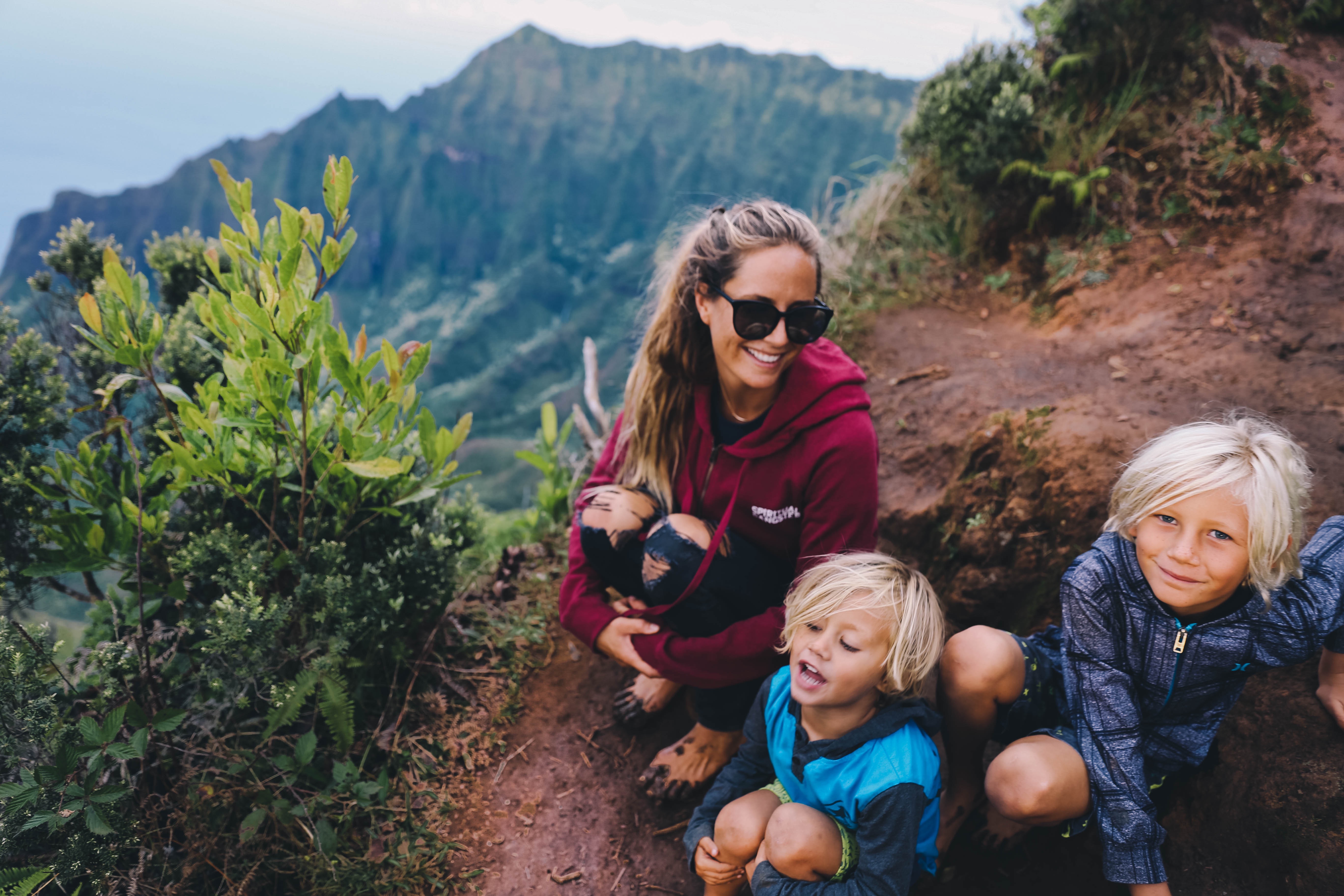 andy and kids sitting on muddy trail